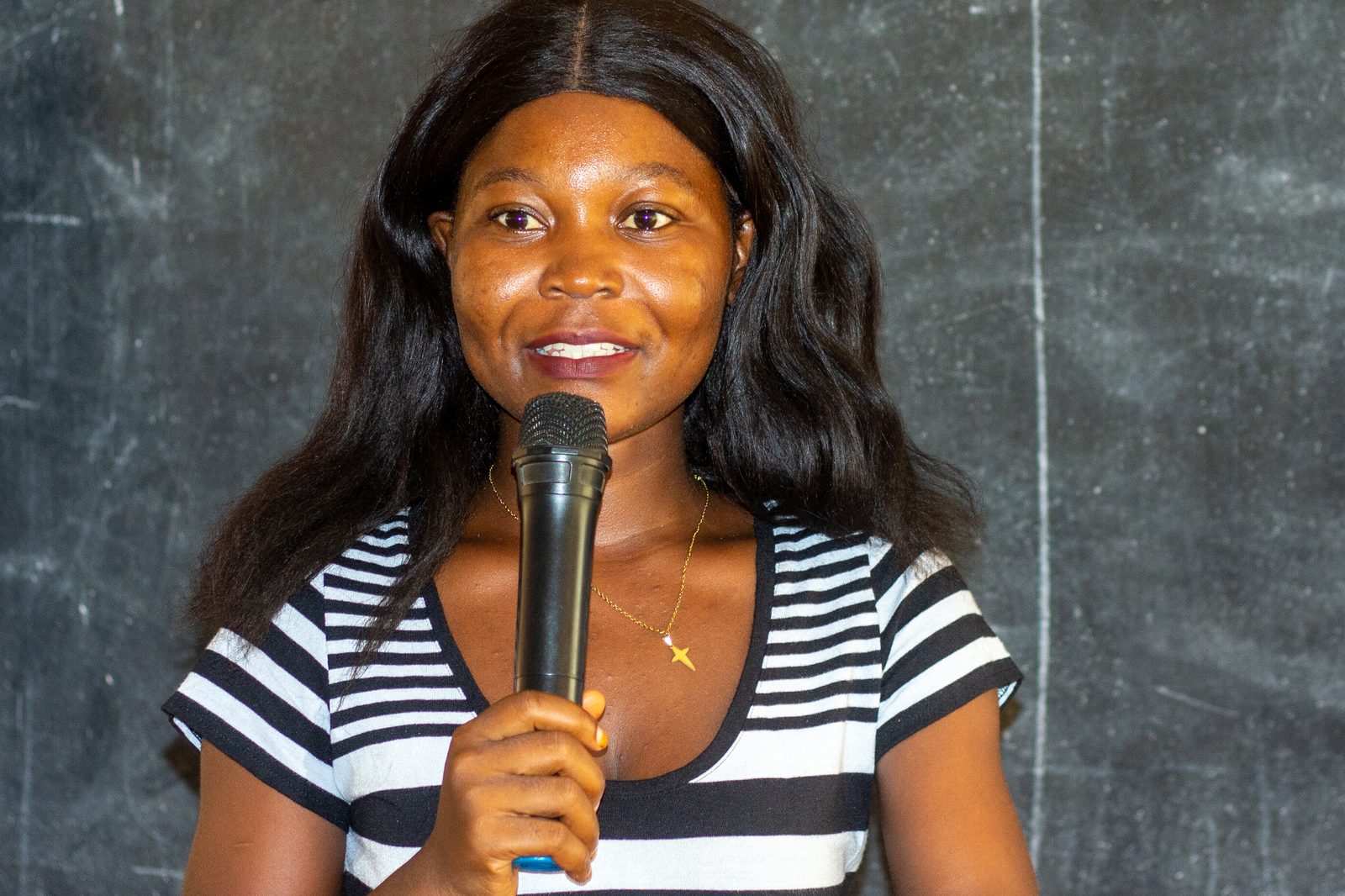 Une membre au micro devant la bannière AIESEC